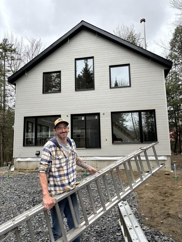 Membre de l'équipe Construction FJL devant une maison en chantier